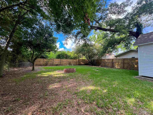 a view of a backyard with large trees