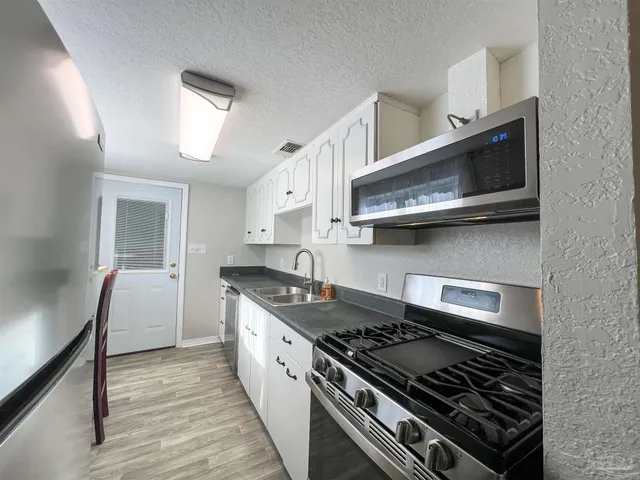 a kitchen with stainless steel appliances granite countertop a stove and a microwave