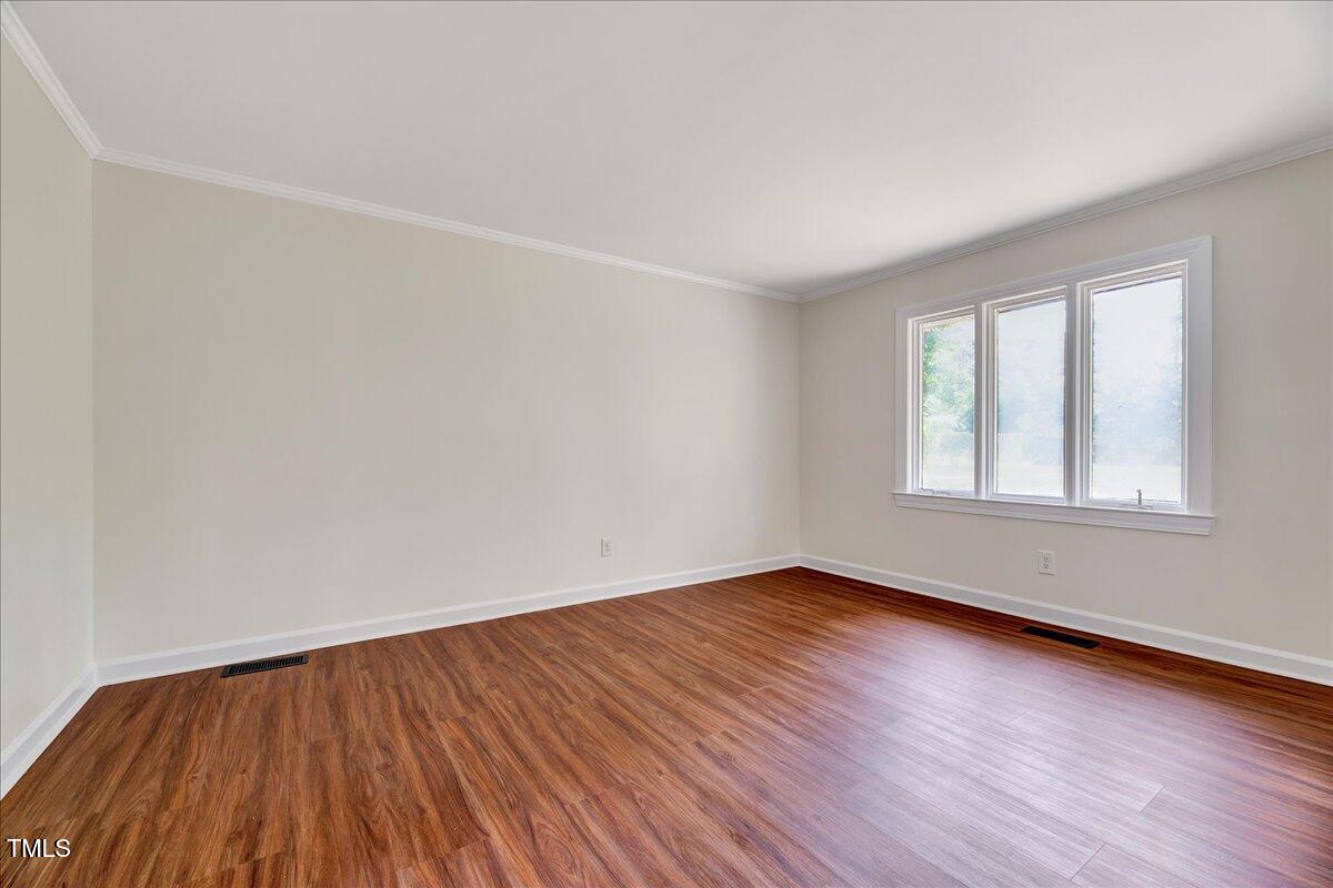 2585 Cabin Branch Road Kinston, NC 28504 - Photo 14 of 42 an empty room with wooden floor and windows
