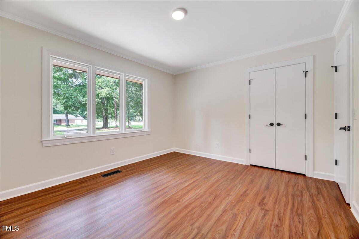 2585 Cabin Branch Road Kinston, NC 28504 - Photo 28 of 42 an empty room with wooden floor and windows