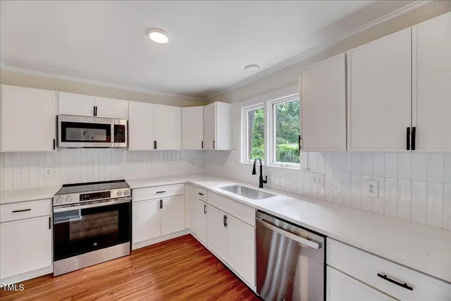 a kitchen with a sink stove and cabinets