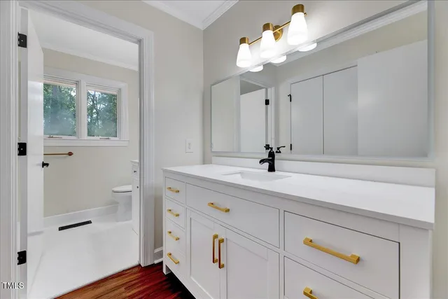 an empty room with wooden floor fireplace and windows