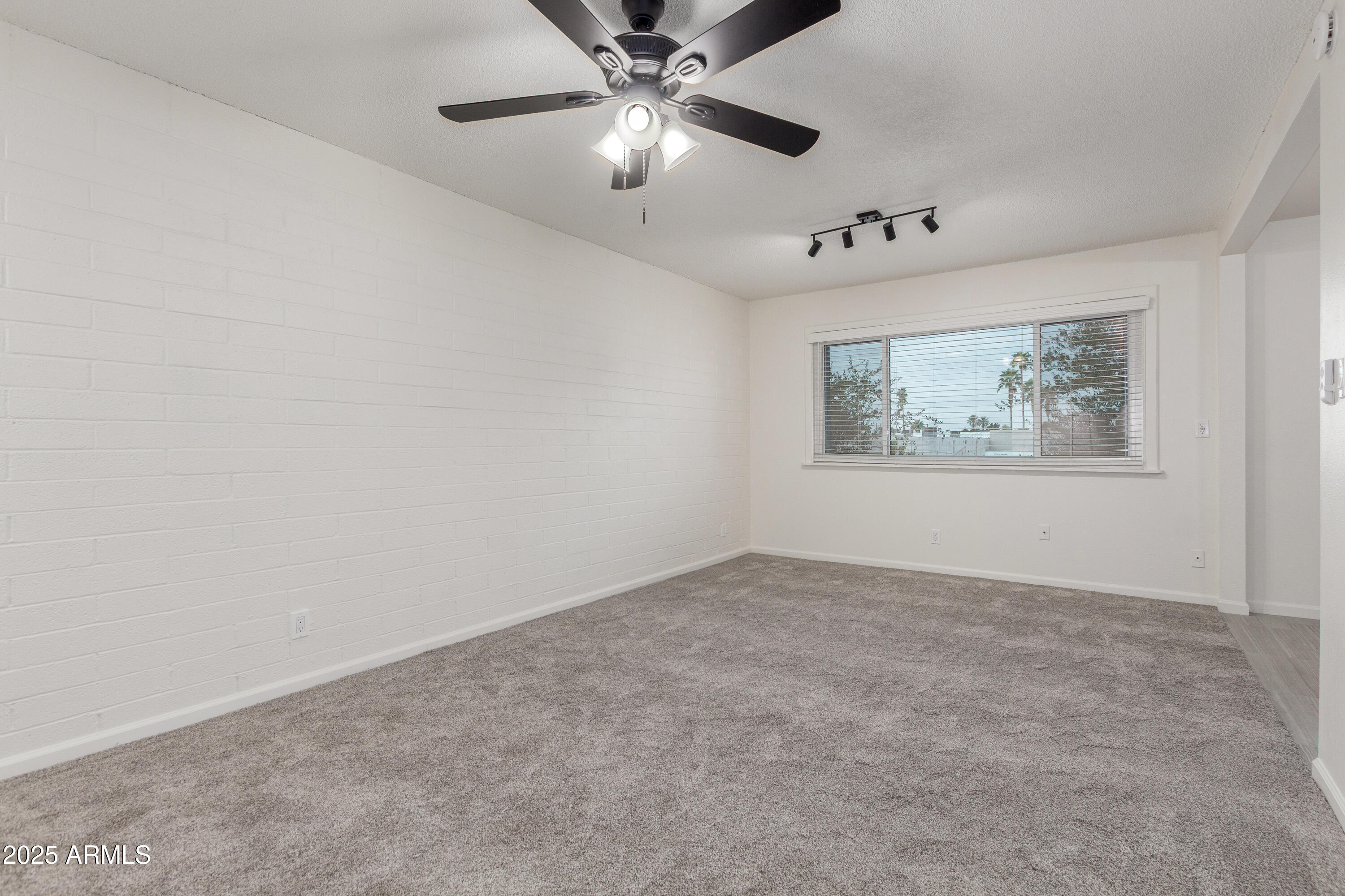 2608 West Berridge Lane, Unit C220 Phoenix, AZ 85017 - Photo 7 of 21 an empty room with windows and fan
