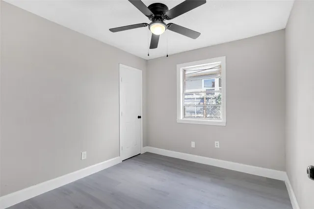 an empty room with a window and a ceiling fan