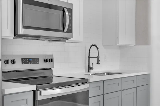 a kitchen with a stove microwave and sink