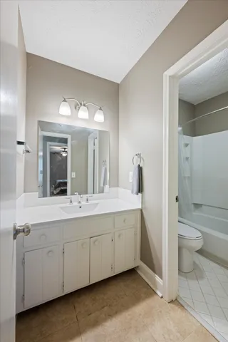 a spacious bathroom with a double vanity sink a toilet and a shower