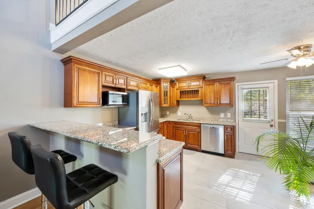 a kitchen with stainless steel appliances granite countertop a stove top oven a sink dishwasher and cabinets with wooden floor