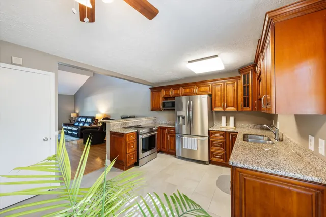 a kitchen with stainless steel appliances granite countertop a sink stove and refrigerator