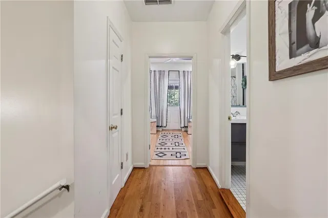 a view of a hallway with wooden floor and staircase