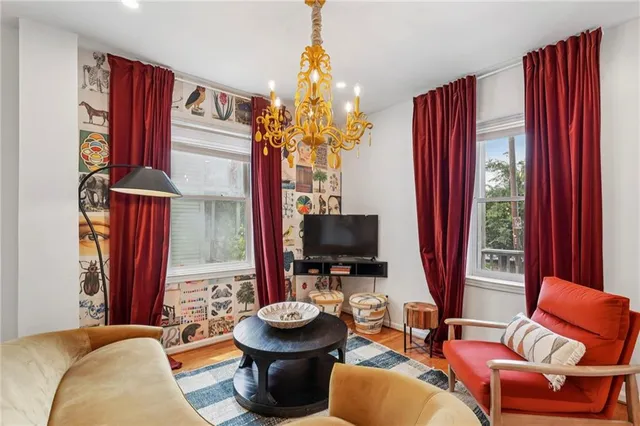 a living room with furniture a flat screen tv and a window