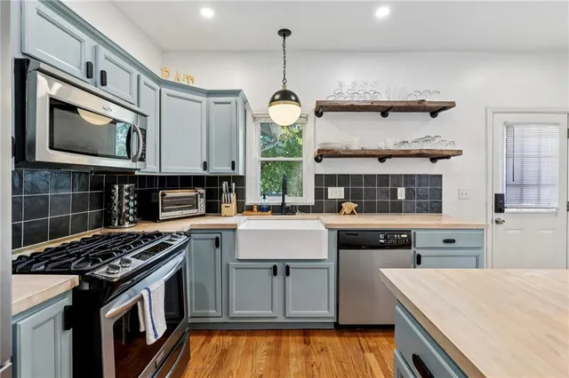 a kitchen with stainless steel appliances granite countertop a stove and cabinets