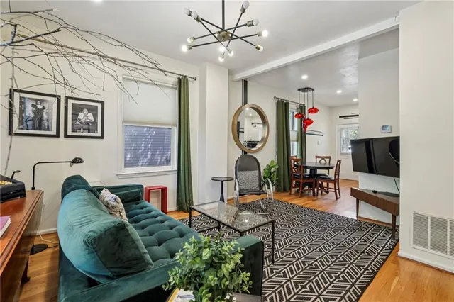 a living room with furniture a flat screen tv and a wall painting