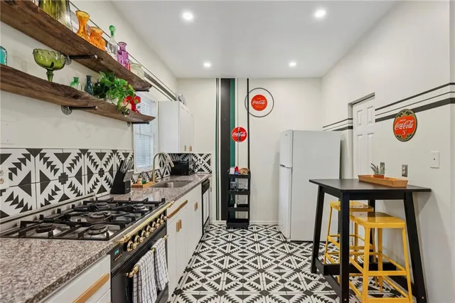 a kitchen with stainless steel appliances granite countertop a stove and a sink