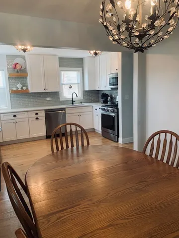 a kitchen with a table chairs microwave and cabinets