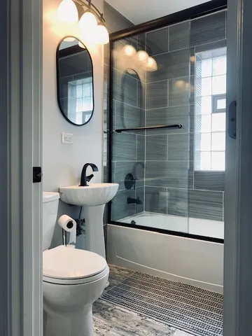 a bathroom with a sink mirror toilet and shower