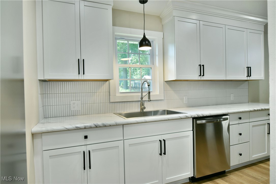 7655 Connelly Road Masury, OH 44438 - Photo 11 of 46 Kitchen featuring stainless steel dishwasher, tasteful backsplash, and white cabinetry