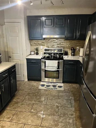 a kitchen with stainless steel appliances granite countertop a stove a sink and a microwave