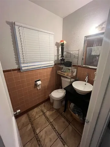 a bathroom with a toilet a sink and a mirror