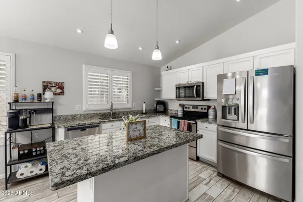 a kitchen with stainless steel appliances granite countertop a refrigerator sink and stove