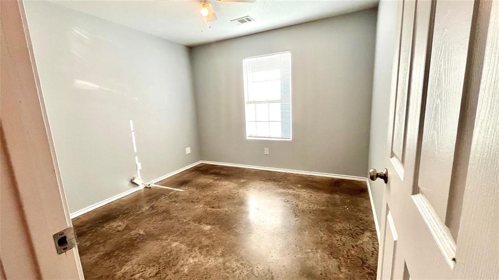 905 West 7th Street Bonham, TX 75418 - Photo 8 of 11 an empty room with wooden floor and windows