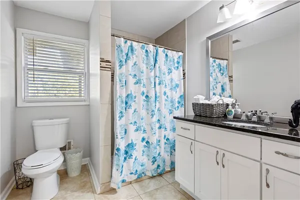 a bathroom with a sink a toilet and shower curtain