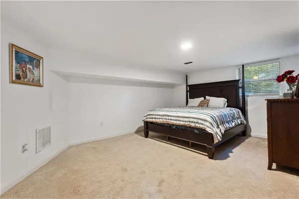 a bedroom with a bed and painting on the wall
