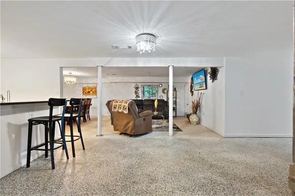a living room with furniture a dining table and a chandelier