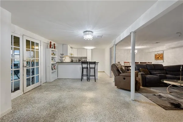 a living room with furniture a large window and kitchen view