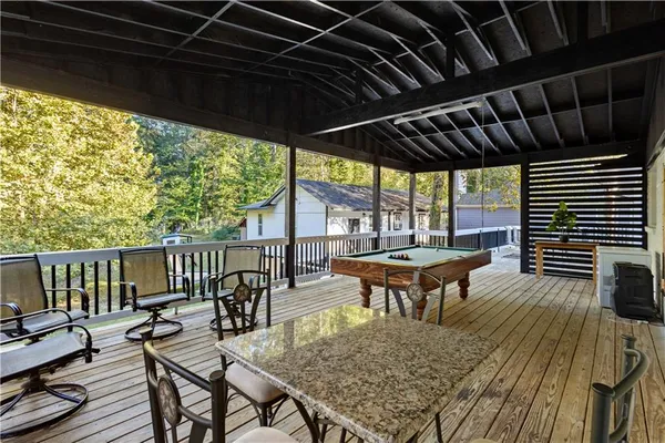 a backyard of a house with wooden floor outdoor seating and yard