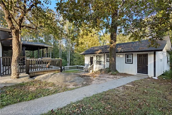 a view of a house with a small yard and a large tree