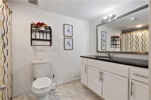 a bathroom with a toilet a sink and mirror