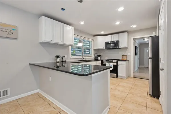 a kitchen with stainless steel appliances granite countertop a sink a stove a refrigerator and cabinets