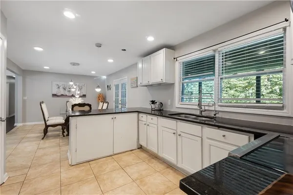 a kitchen with granite countertop a sink and white cabinets