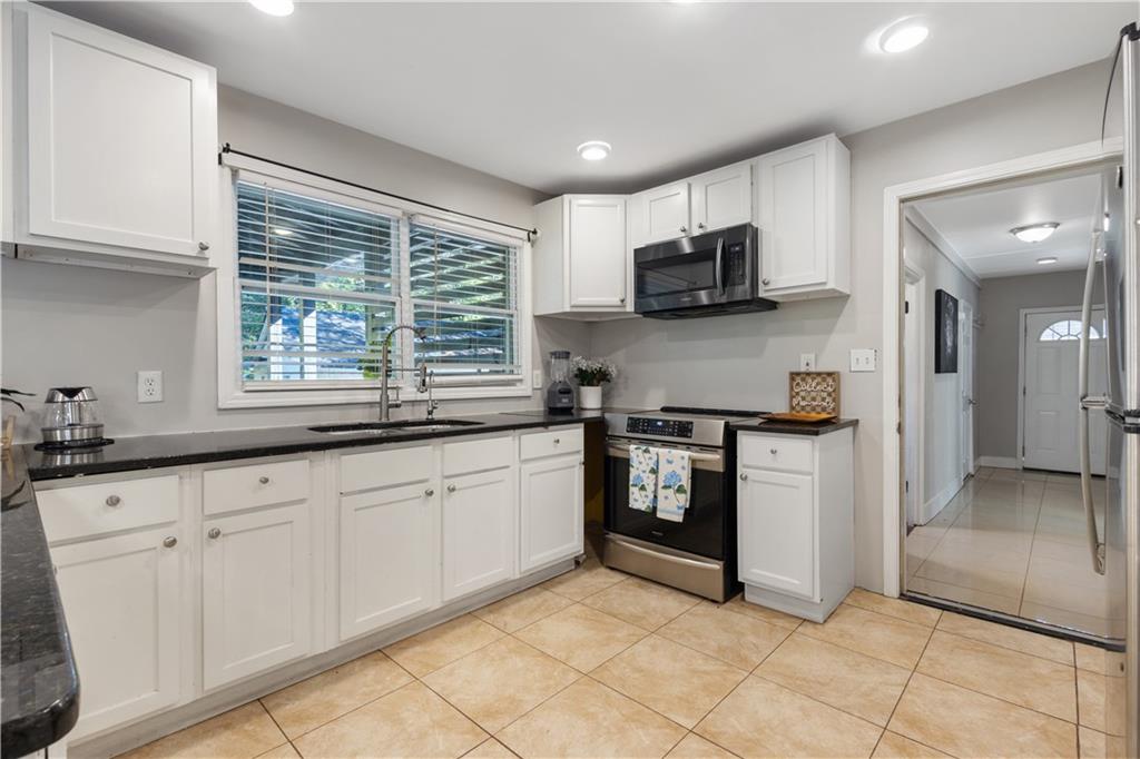 154 Dollar Mill Road Southwest Atlanta, GA 30331 - Photo 10 of 42 a kitchen with granite countertop white cabinets and stainless steel appliances