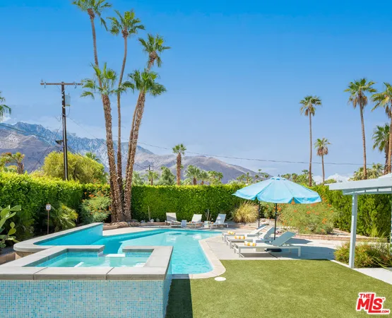 a view of a swimming pool with a lawn chairs under an umbrella