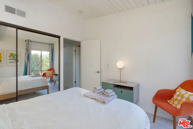 a bedroom with bed and wooden floor