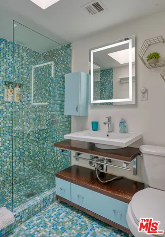 a bathroom with a sink mirror vanity and toilet