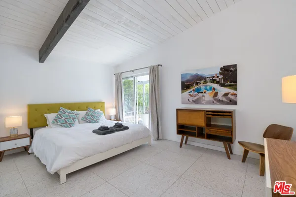 a bedroom with a bed and a painting on the wall