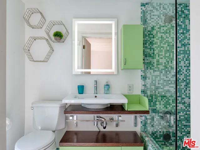 a bathroom with a toilet a sink and mirror