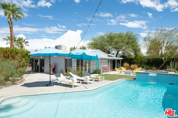 a view of a house with a yard patio and fire pit