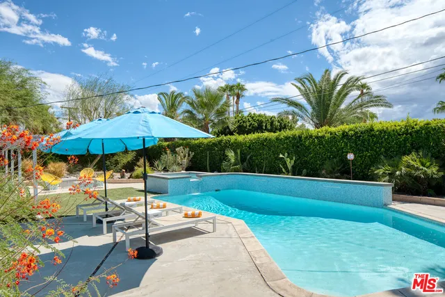 a view of a terrace with a table and chairs under an umbrella