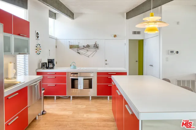 a kitchen that has a lot of cabinets in it and wooden floors