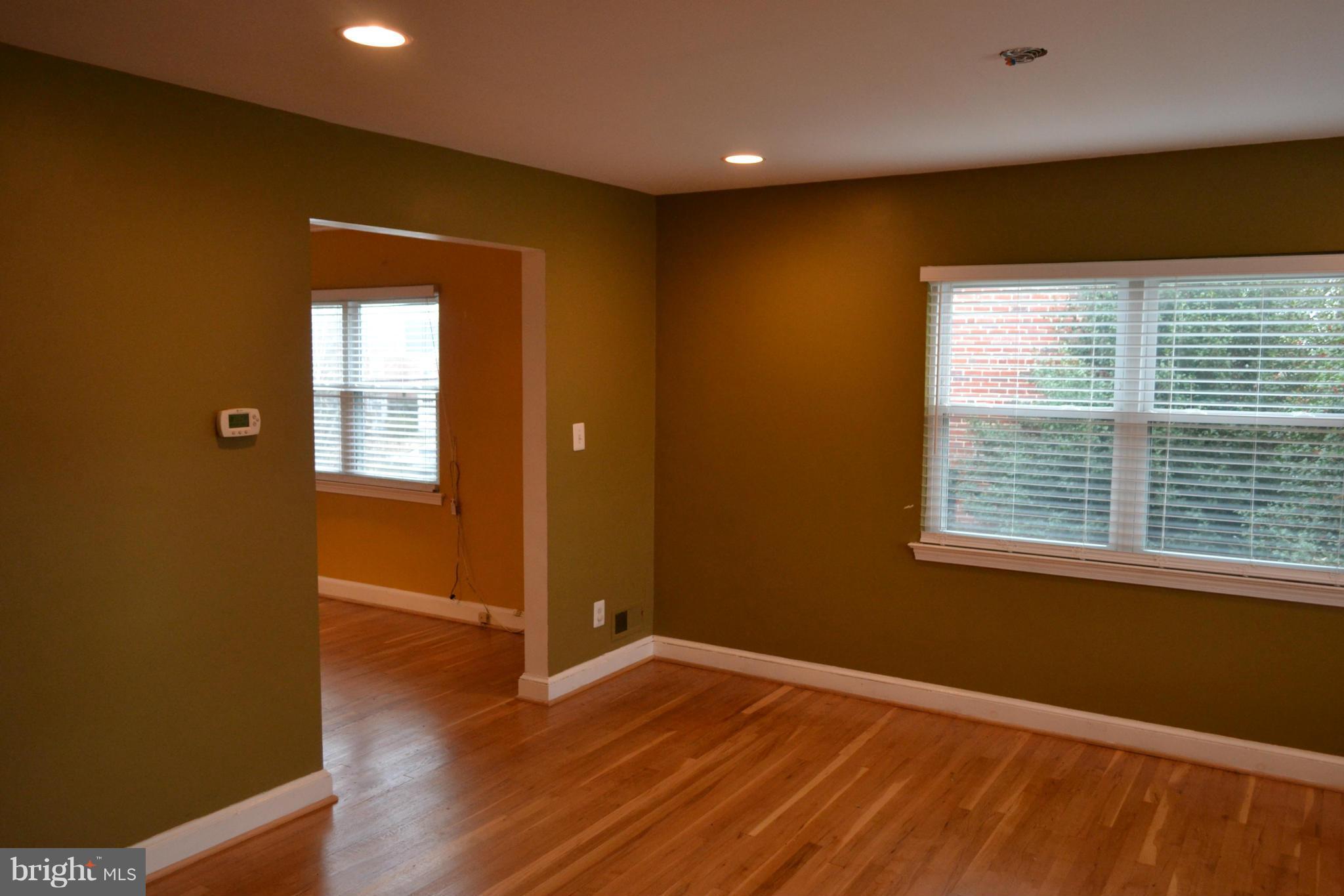 842 Bradhurst Road Baltimore, MD 21212 - Photo 2 of 28 a view of an empty room with wooden floor and a window