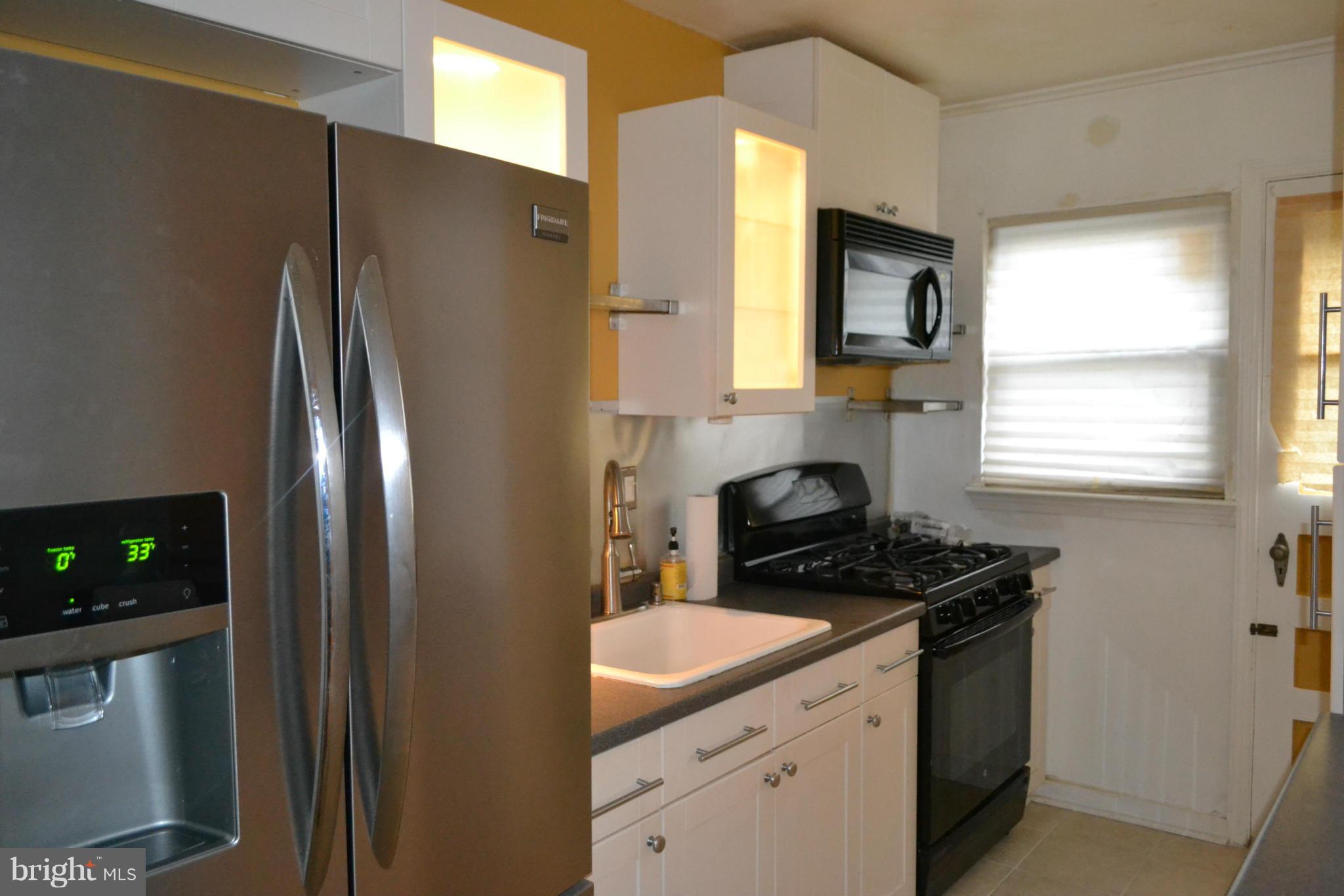 842 Bradhurst Road Baltimore, MD 21212 - Photo 12 of 28 a kitchen with stainless steel appliances granite countertop a refrigerator a sink and a stove