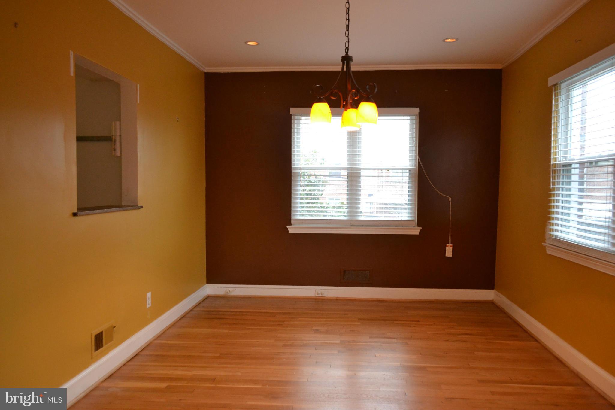 842 Bradhurst Road Baltimore, MD 21212 - Photo 9 of 28 a view of an empty room with a window and wooden floor
