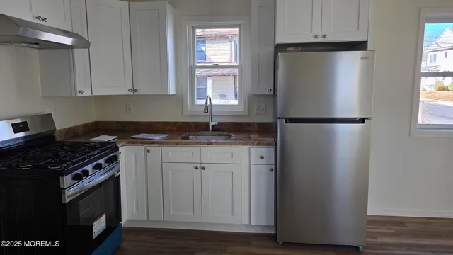 a kitchen with a refrigerator stove and cabinets
