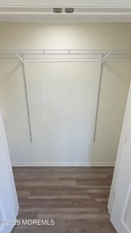 a view of a small space with wooden floor and a window