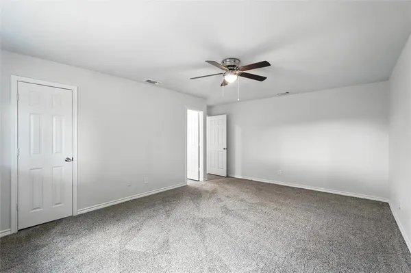 a view of an empty room with a ceiling fan