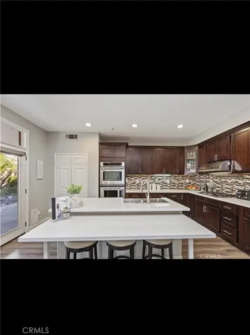 a kitchen with stainless steel appliances a sink stove and cabinets