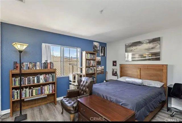 a bedroom with a bed a book shelf and a window